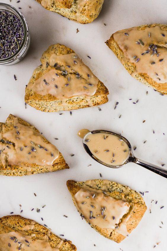 triangular scones in an every-other diagonal pattern across a white background; the scones are glazed and dusted with lavender buds