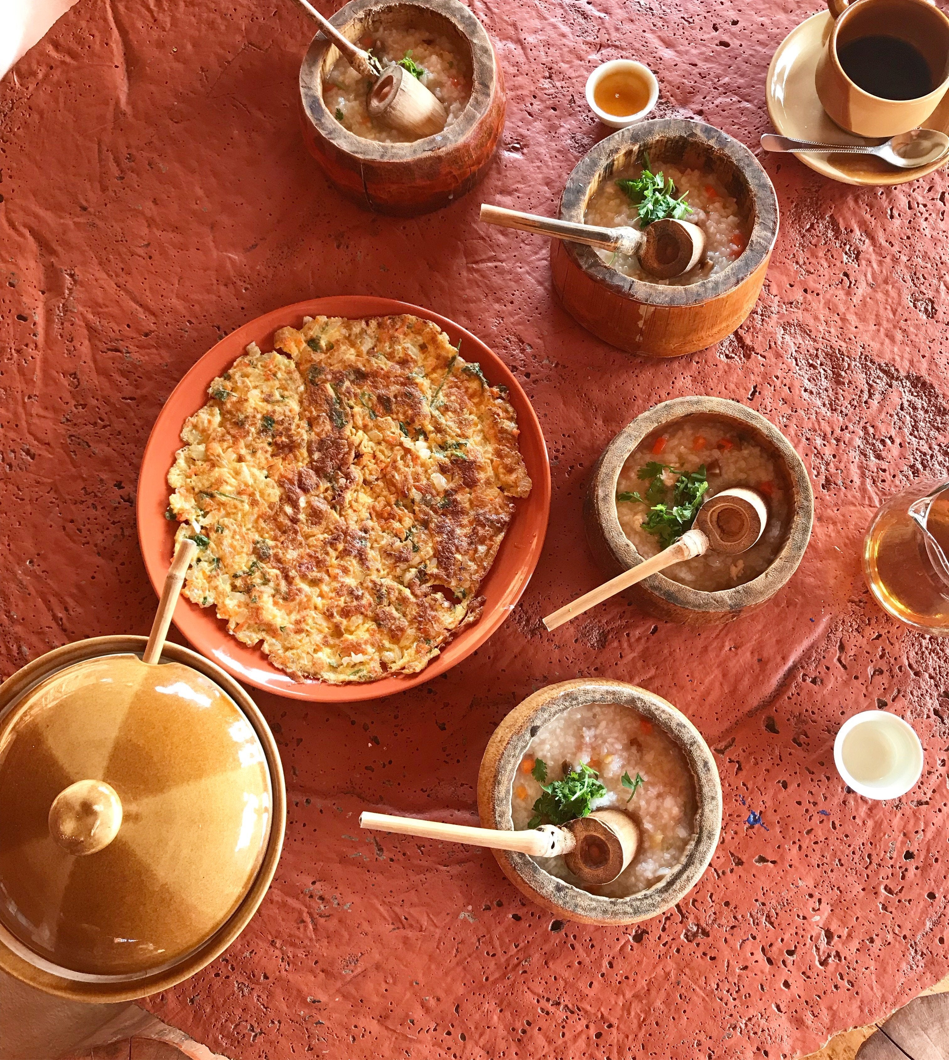 an array of thai soup dishes on a red wood table