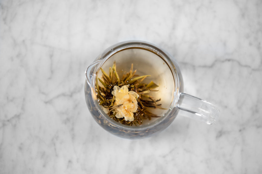 aerial view of a blooming jasmine tea in a glass teapot