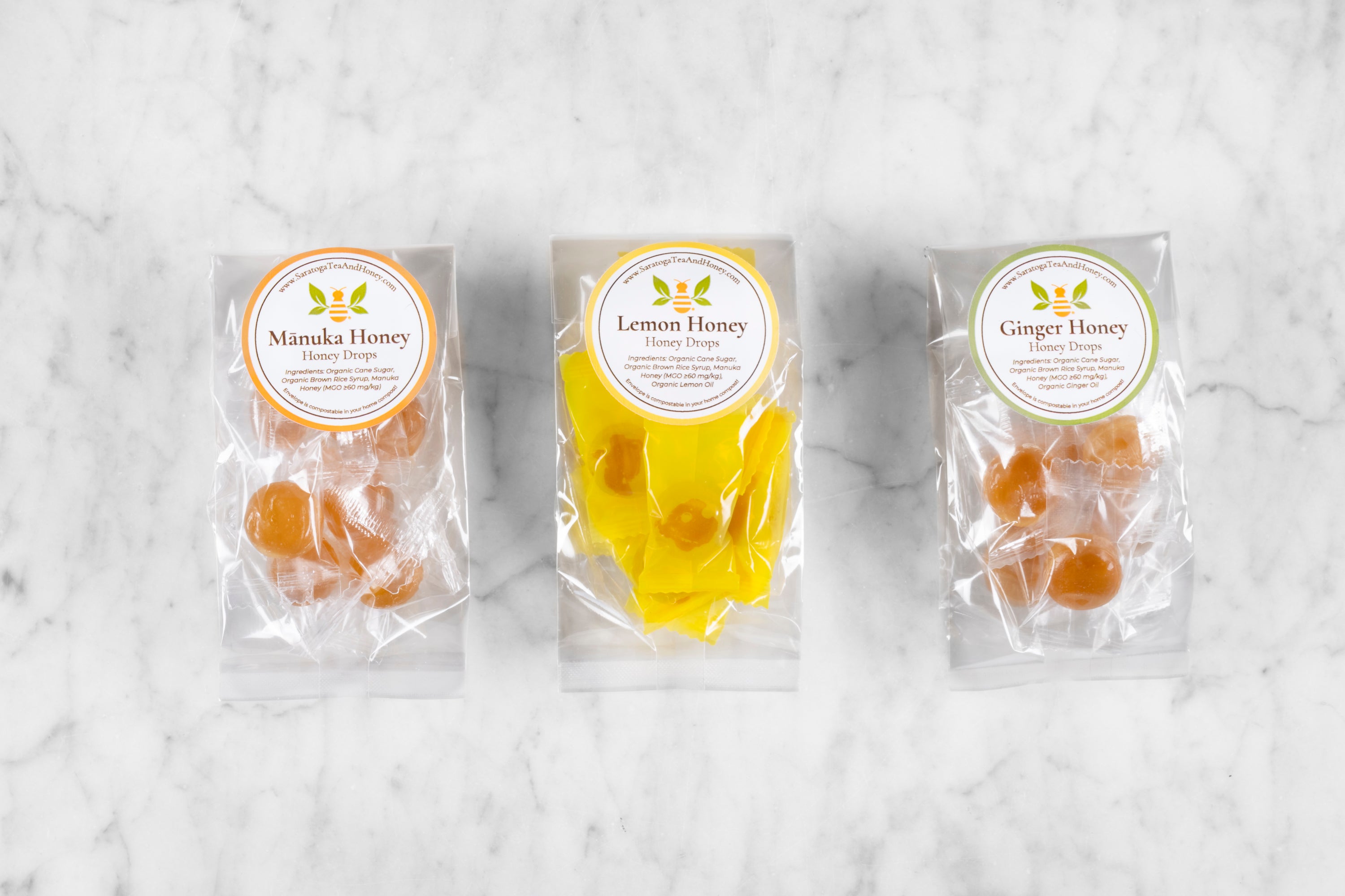 three small packages of honey candy from left to right: manuka honey candy, lemon honey candy, ginger honey candy