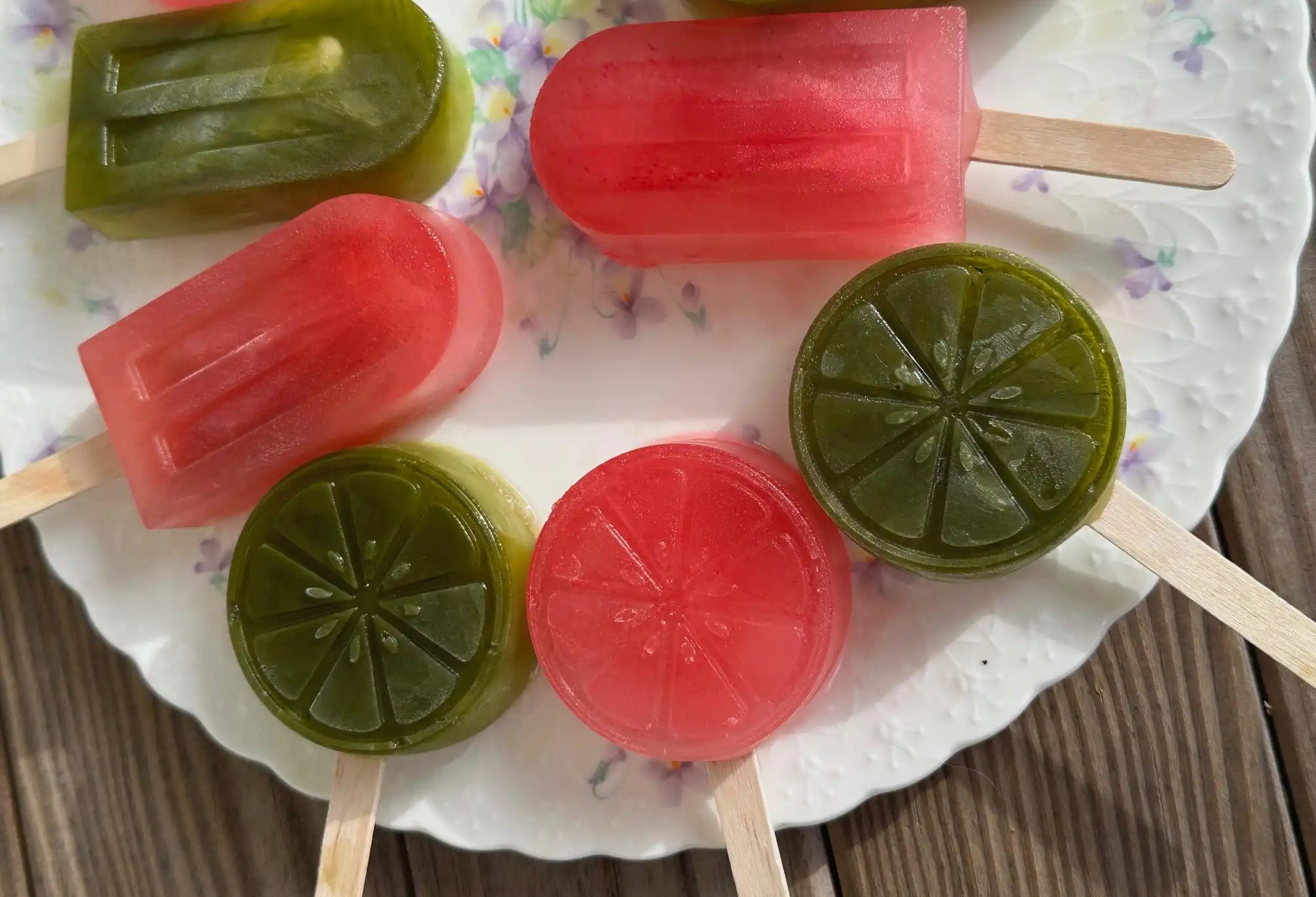 matcha lemonade and iced tea lemonade ice pops in a semi circle on a white plate 