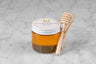 3oz jar of Italian Orange Blossom Honey with twine and mini dipper on a marble background