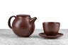 minimalist brown teapot and matching cup and saucer