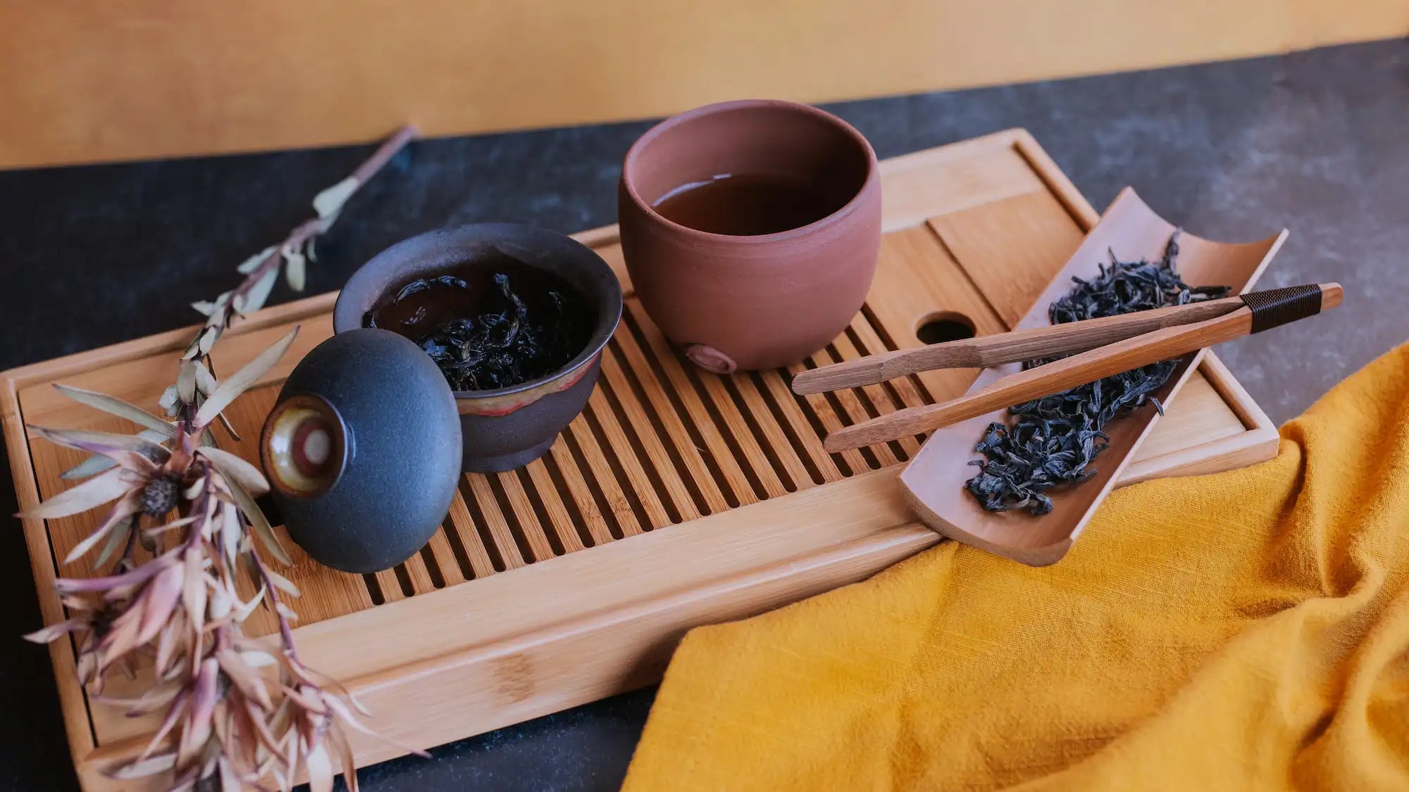 shui xian lao cong chinese oolong in a gaiwan with a sharing pitcher and loose dry oolong on a bamboo tea boat