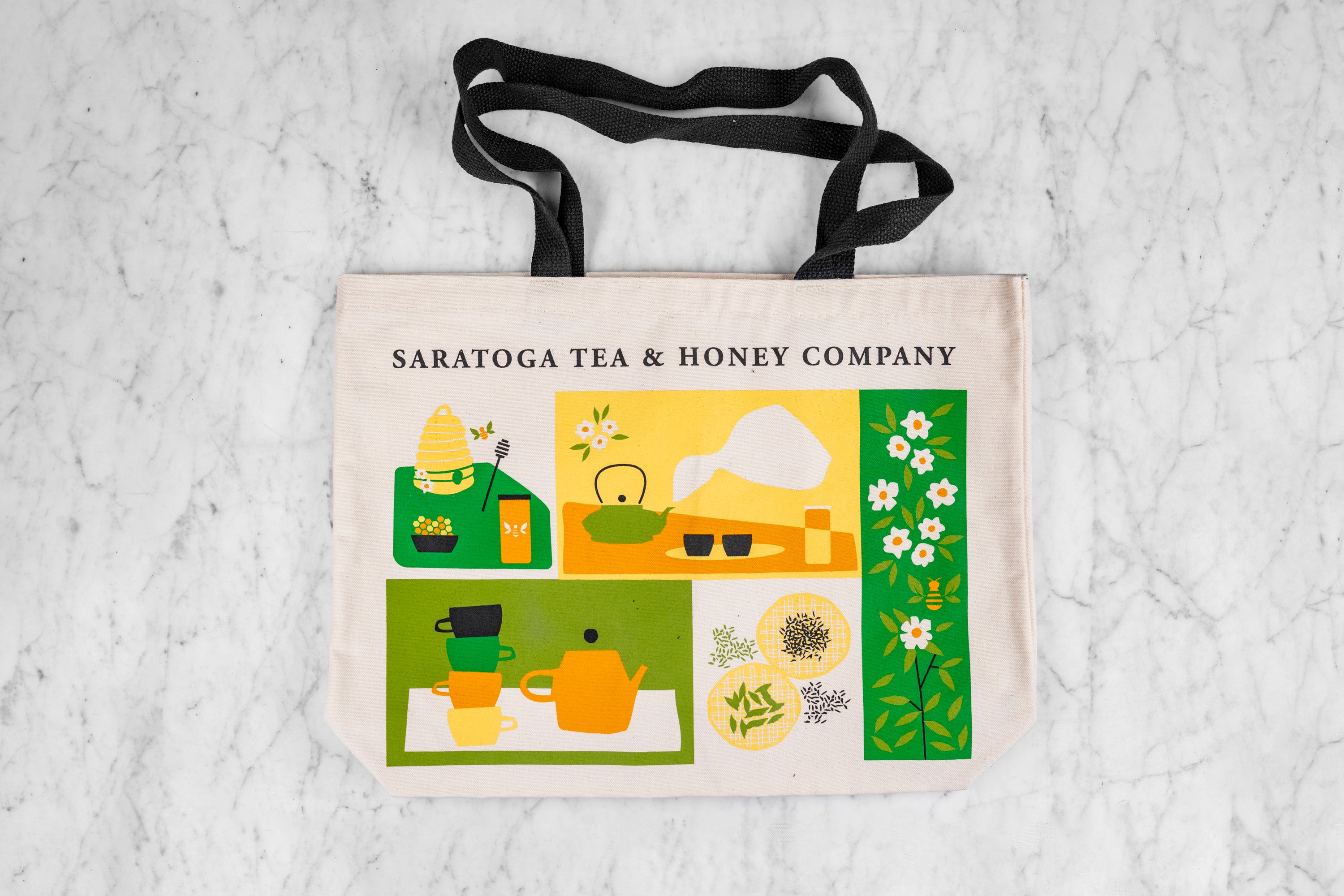 flat lay of Saratoga Tea & Honey Co. tea and honey graphics tote bag