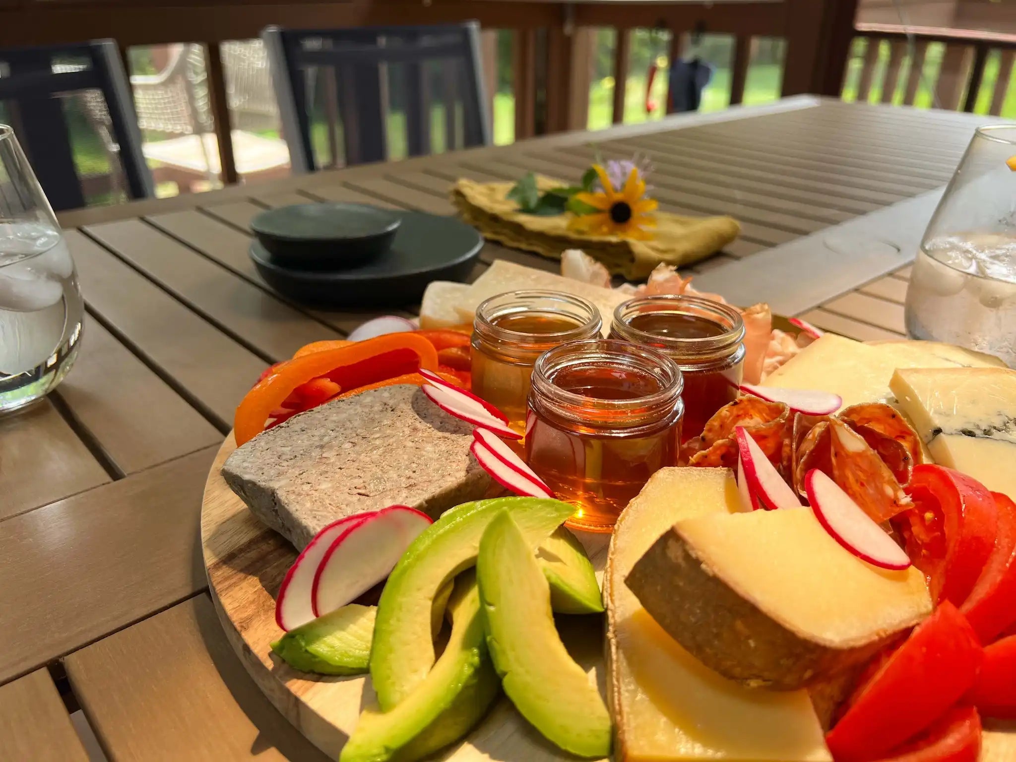 charcuterie board with honey on a patio table