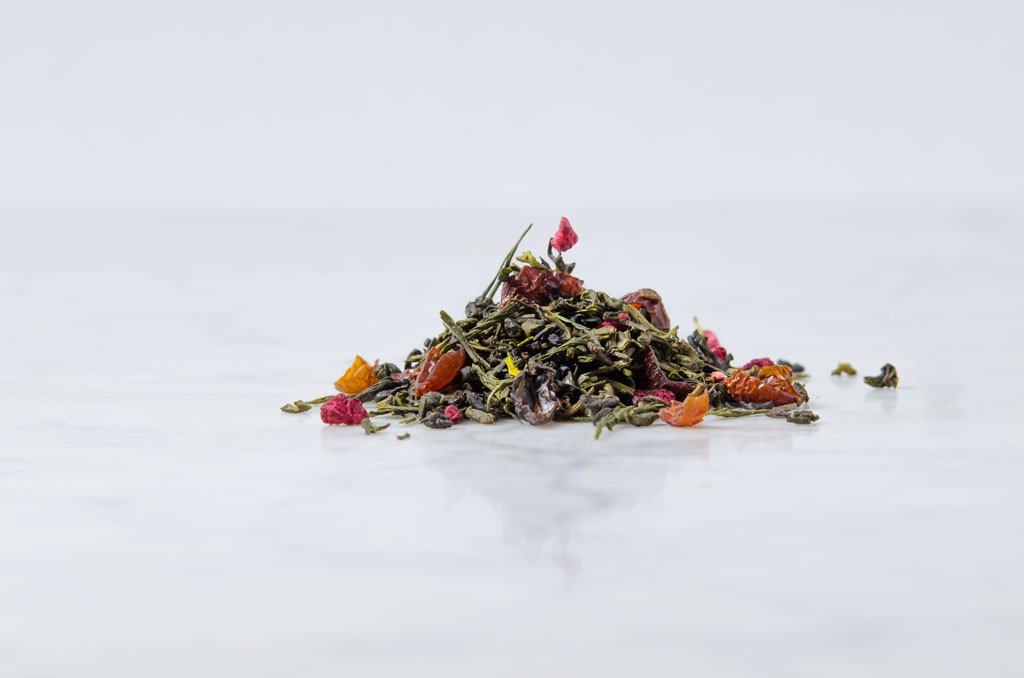 loose leaf pomegranate green tea leaves on a marble background